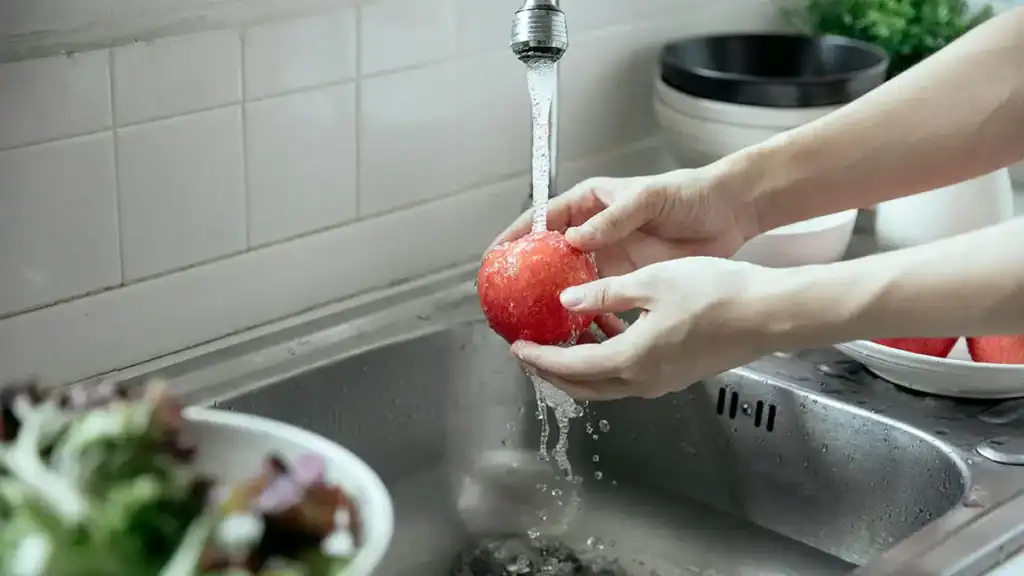 Lavare frutta sotto l'acqua corrente